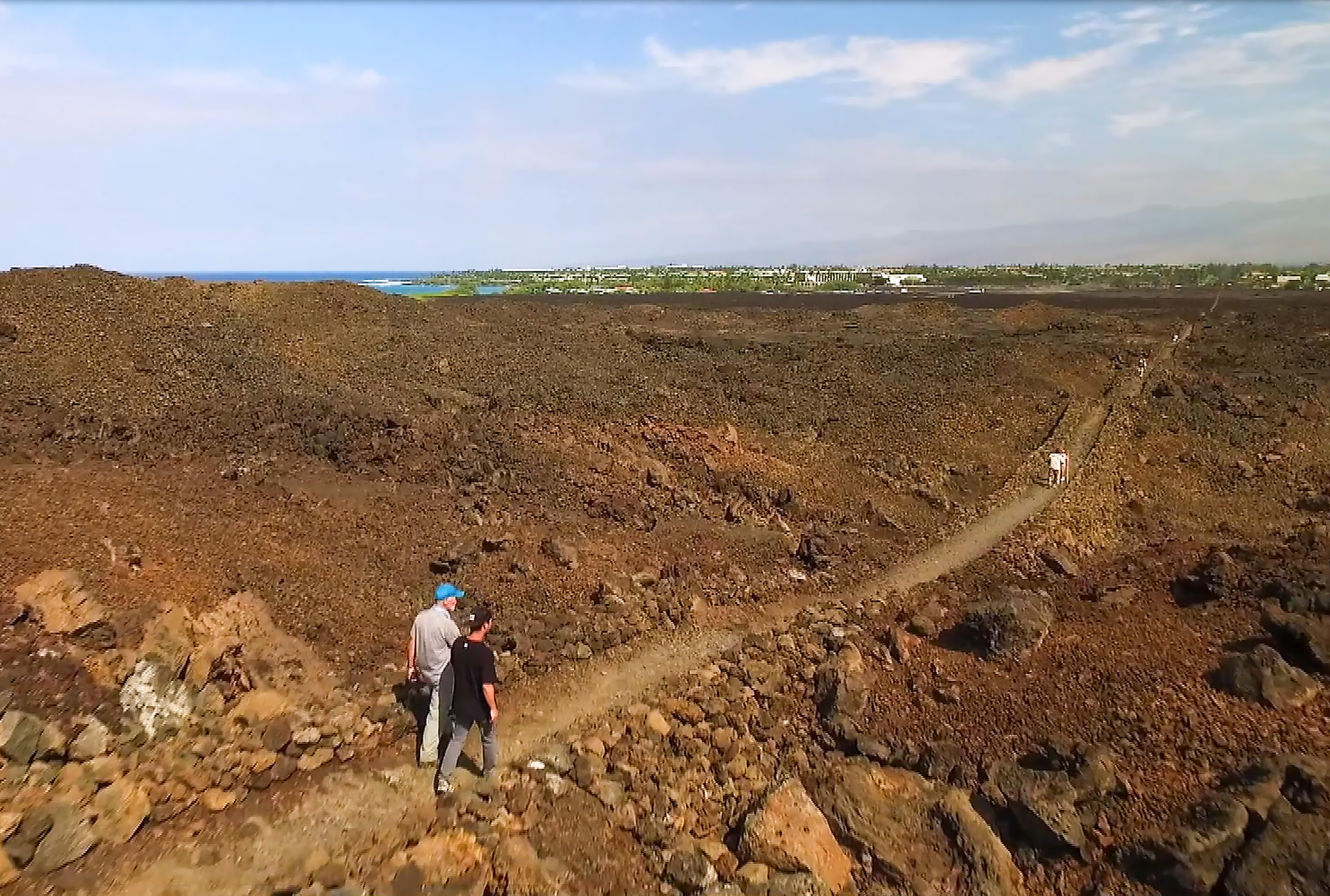 Aerial photograph of hikers along straight rocky segment of Ala Kahakai