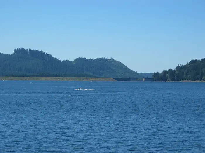 A boat on Dorena Lake with the dam in the background