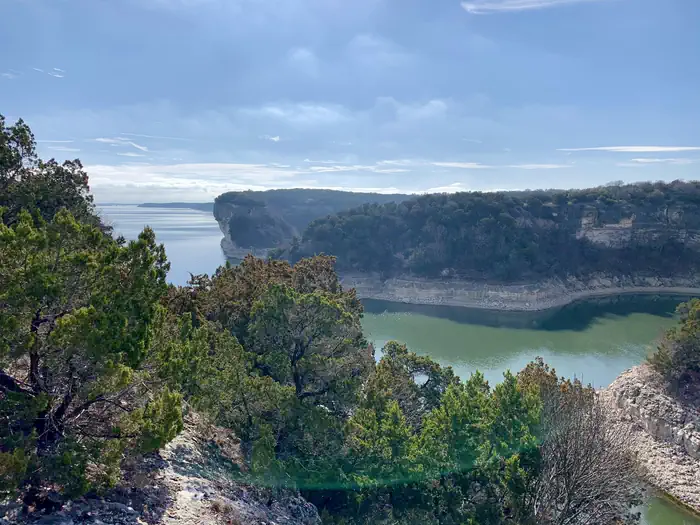 Limestone bluffs covered with ashe juniper trees surrounding Whitney Lake.